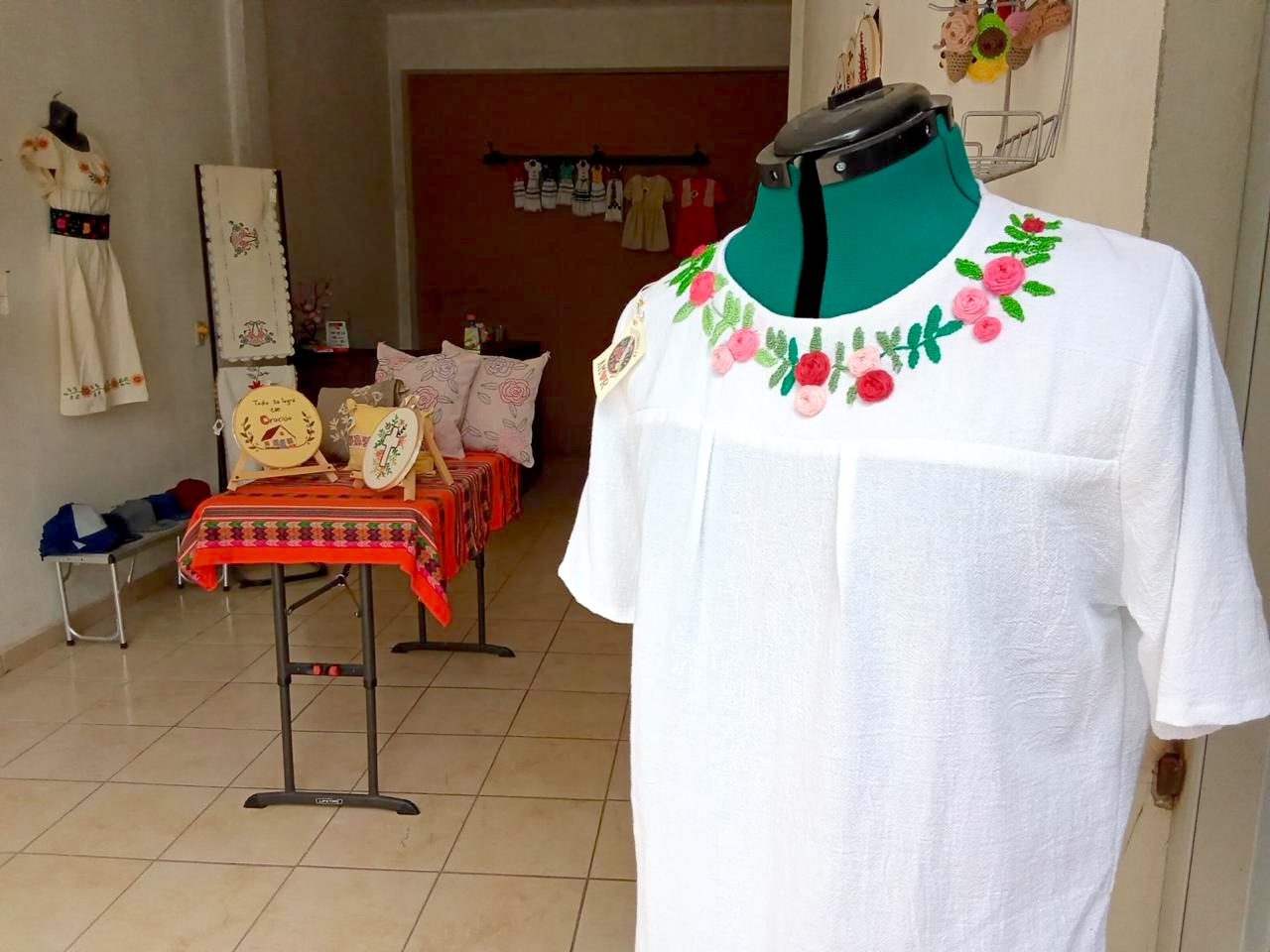 Blusa blanca con rosas bordadas en relieve alrededor del cuello