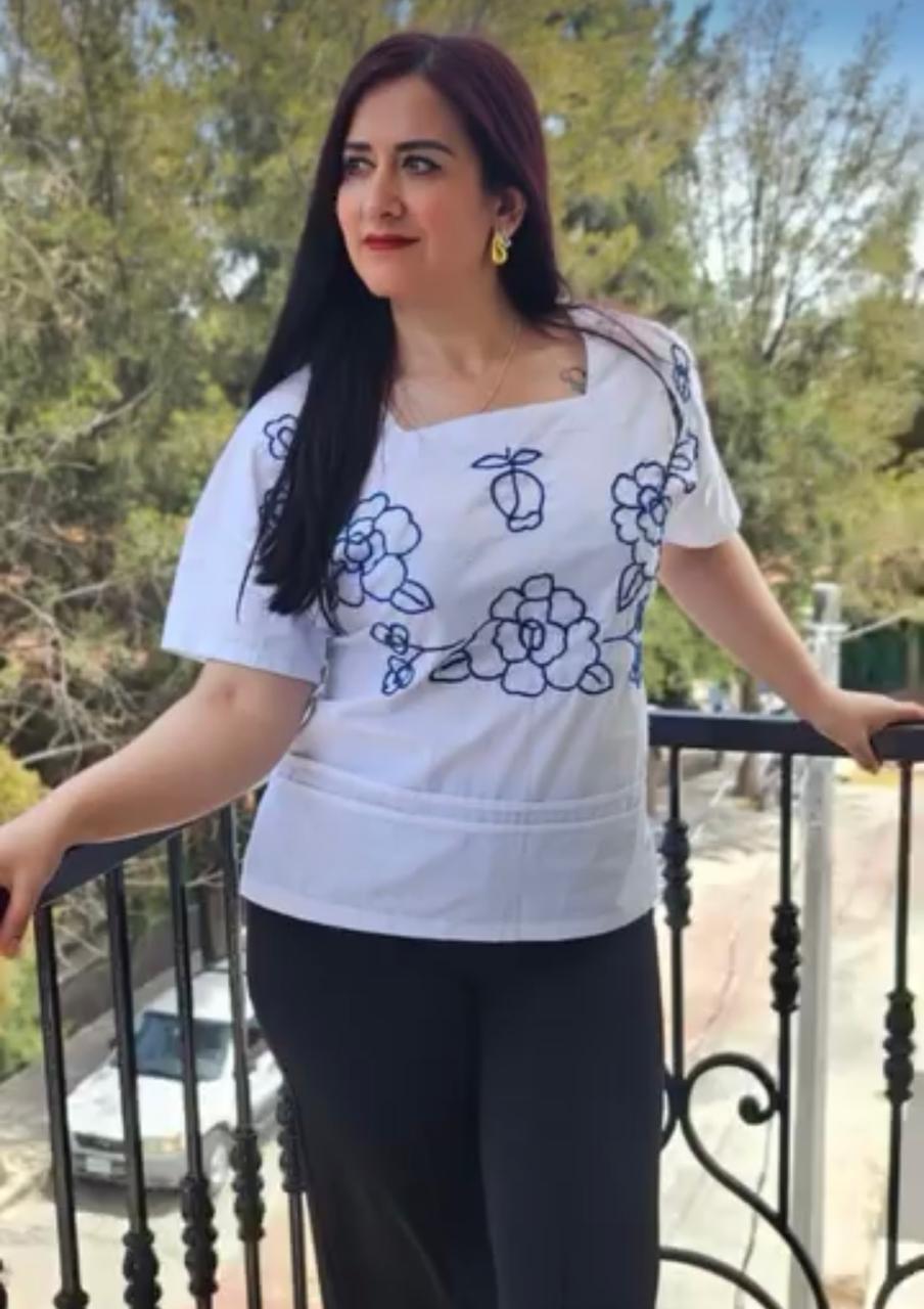 Mujer con blusa blanca bordada con flores azules