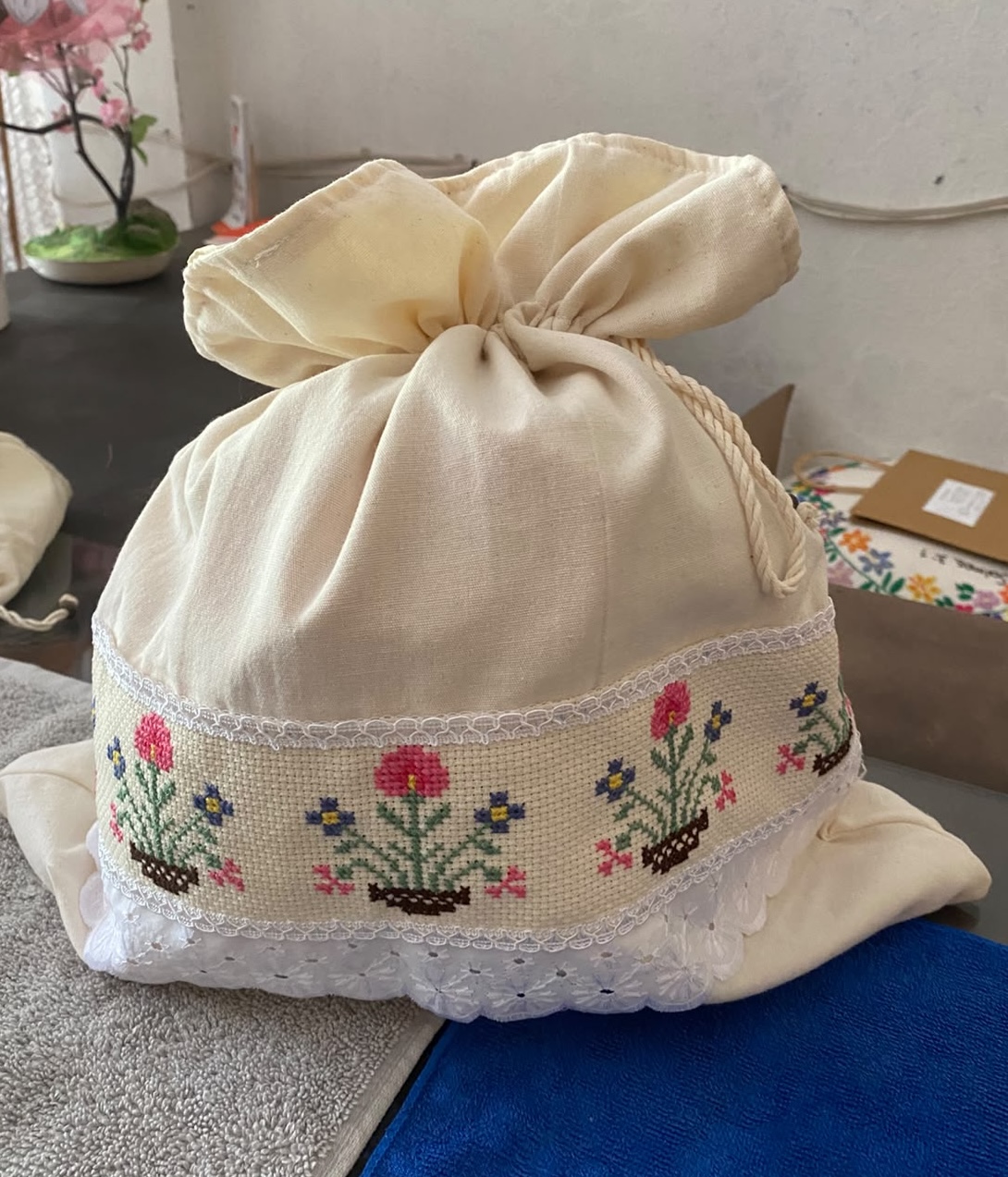 Bolsa para pan de tela blanca con flores bordadas y encaje
