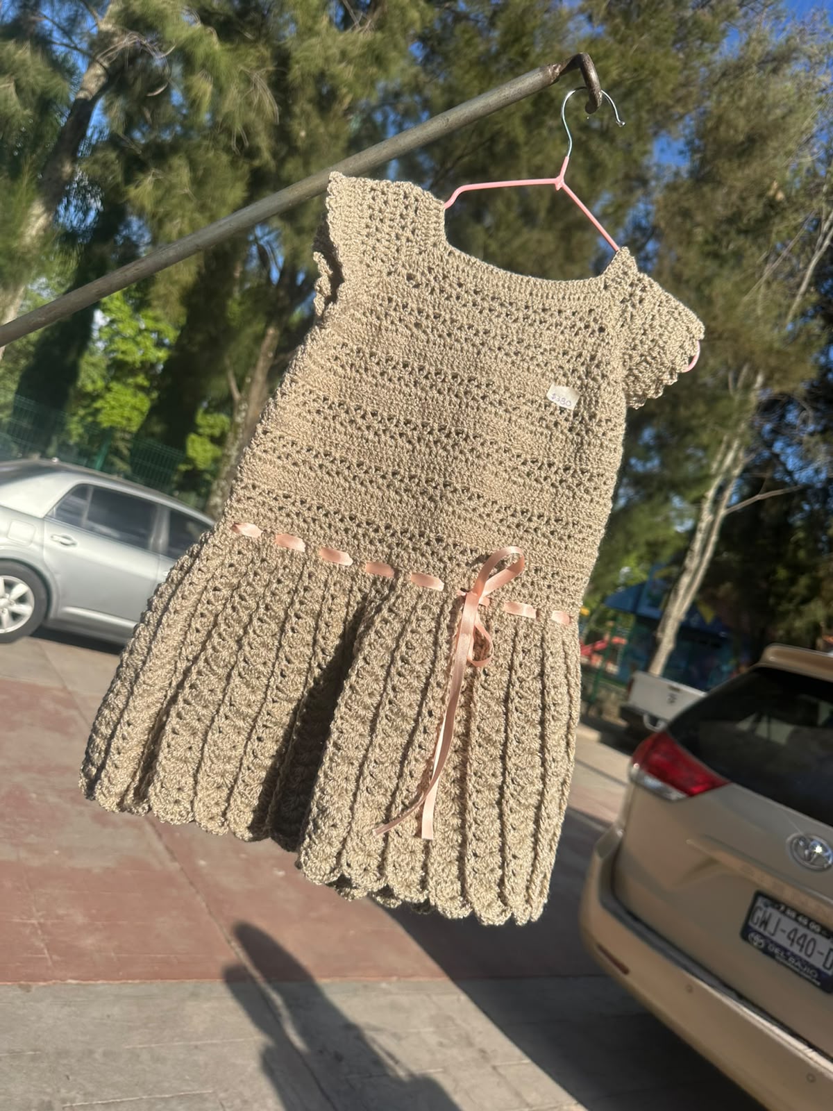 Vestido infantil beige tejido a mano con listón rosa