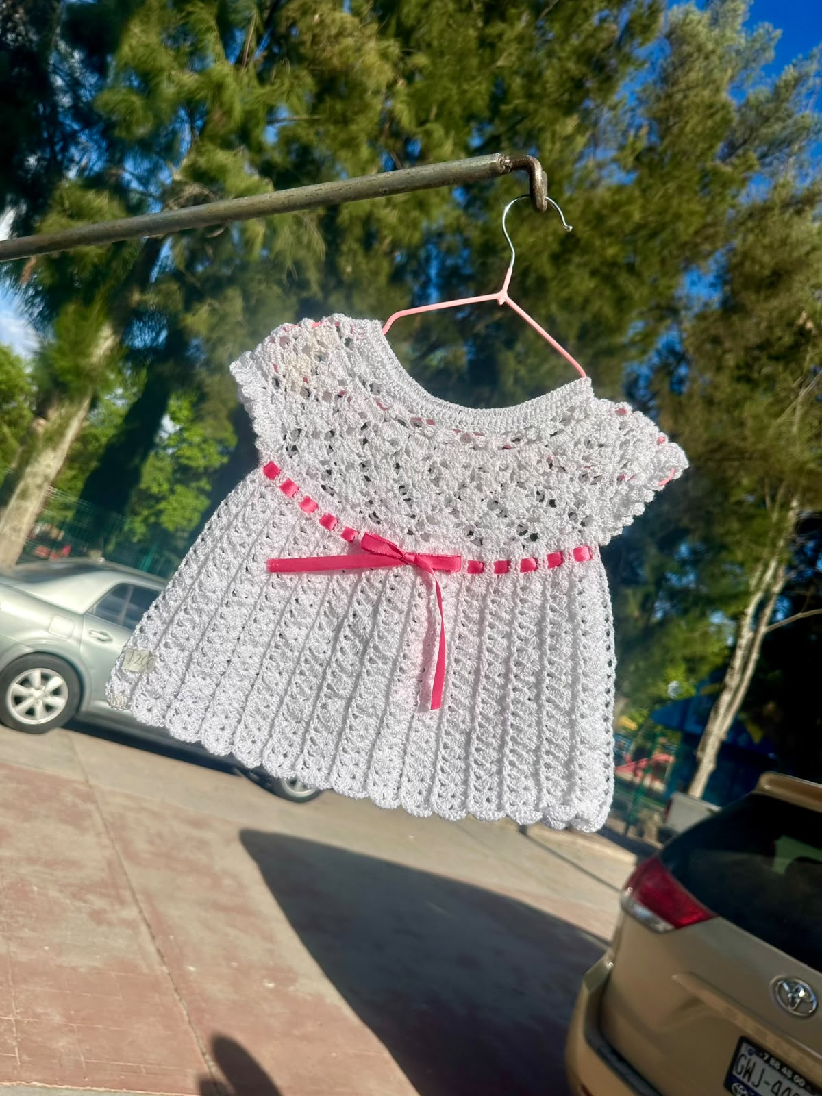 Vestido infantil blanco tejido a mano con listón rosa