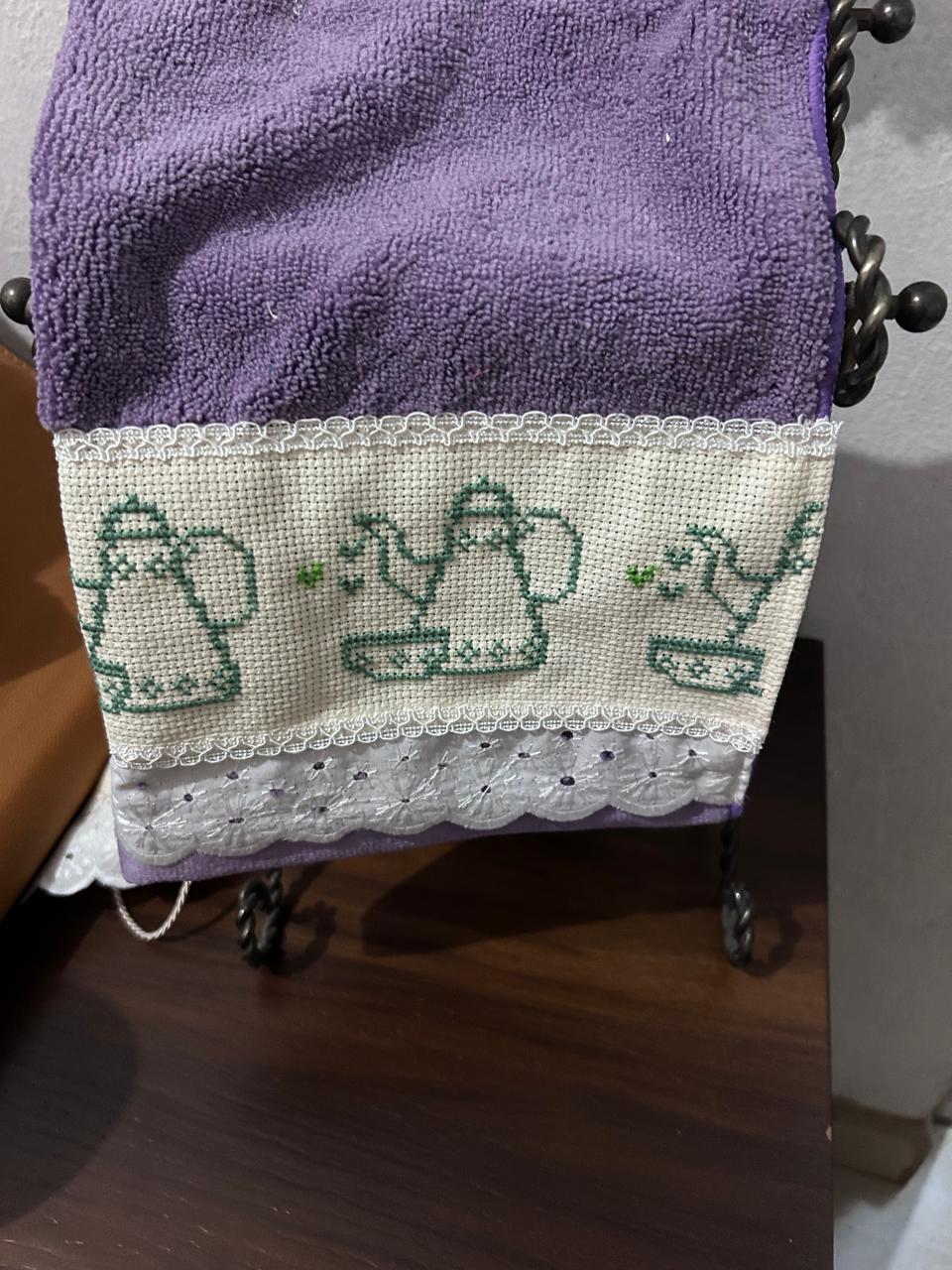 Toalla lila con teteras bordadas en cenefa
