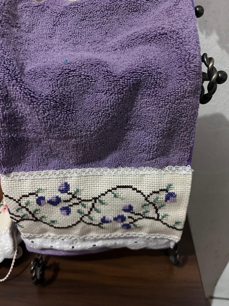 Toalla lila con flores bordadas en cenefa