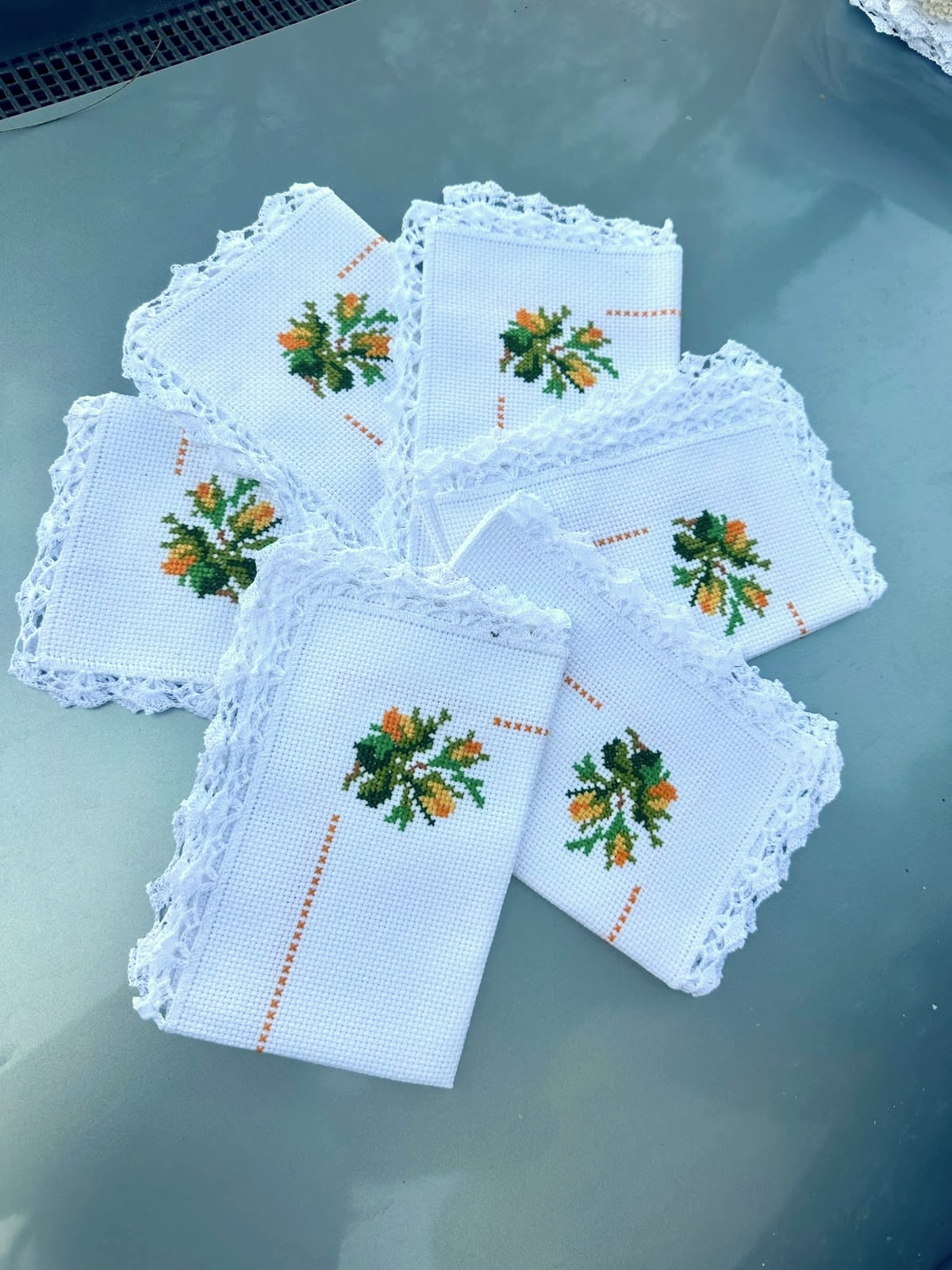Juego de servilletas blancas con flores naranjas bordadas