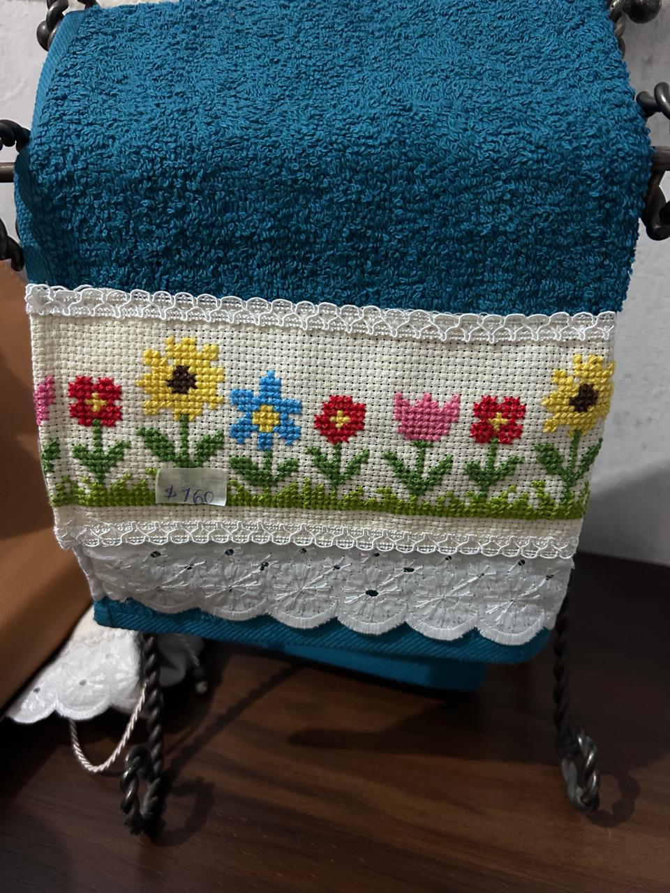 Toalla verde azulado con flores bordadas en punto de cruz