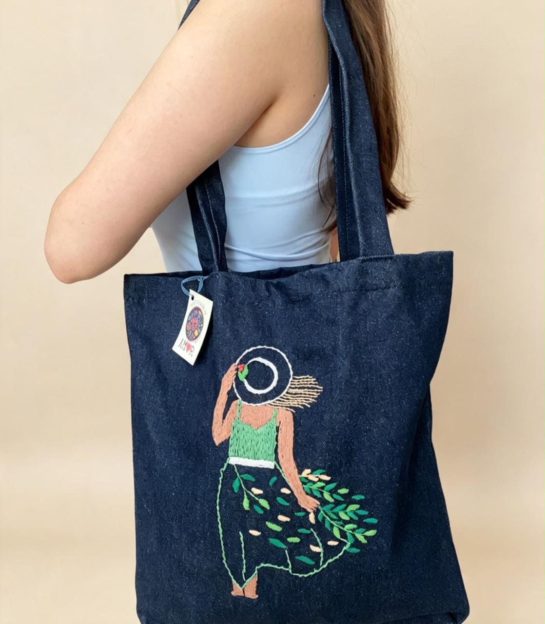 Bolsa de mezclilla con figura femenina y motivos botánicos bordados