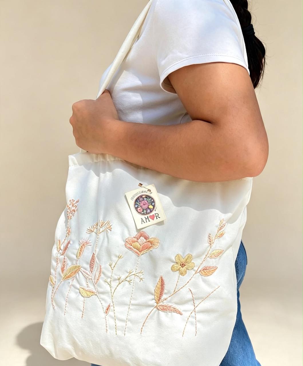Bolsa de tela cruda con flores bordadas en tonos cálidos